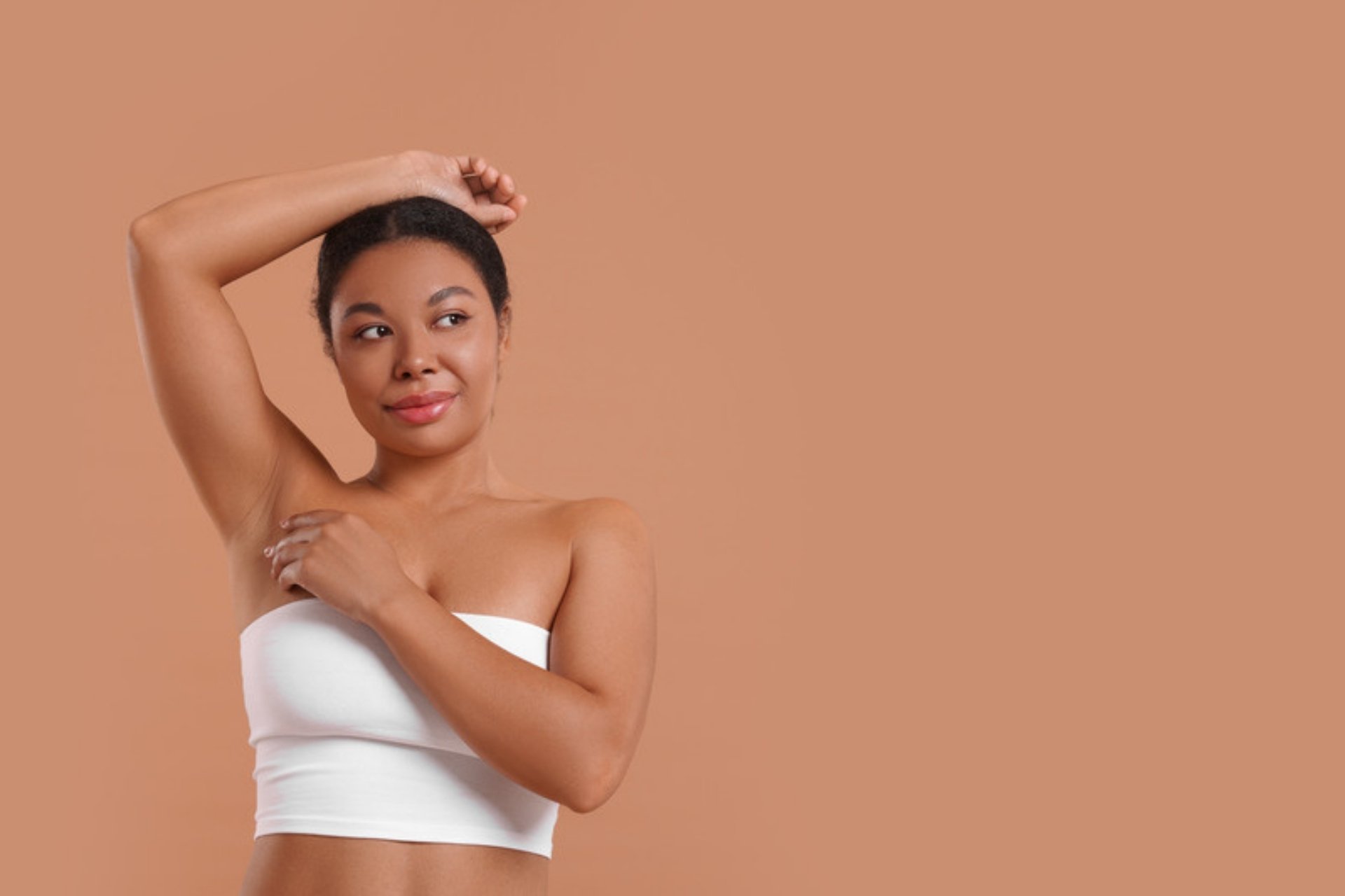 Woman with her arm raised showing a smooth underarm after laser hair removal
